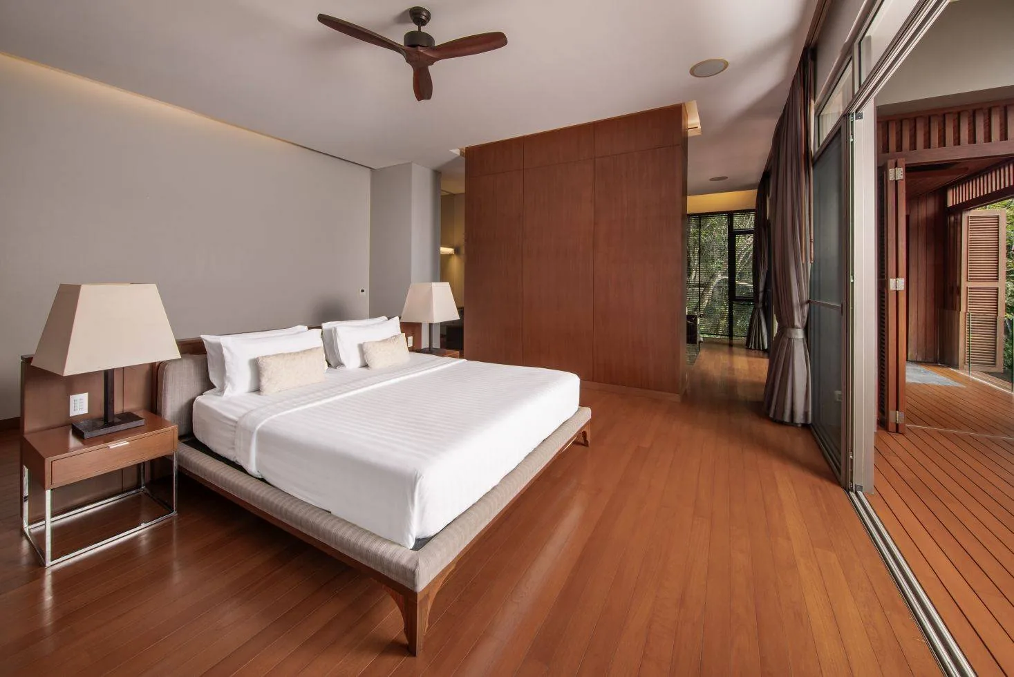 A bedroom with a bed and wood flooring