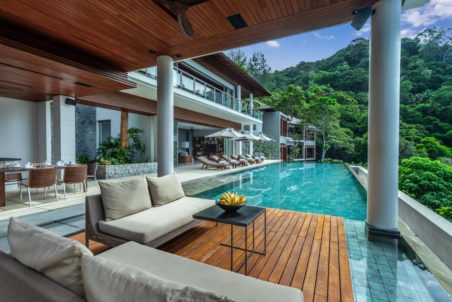 An outdoor lounge seating area beside the pool, with a coffee table
