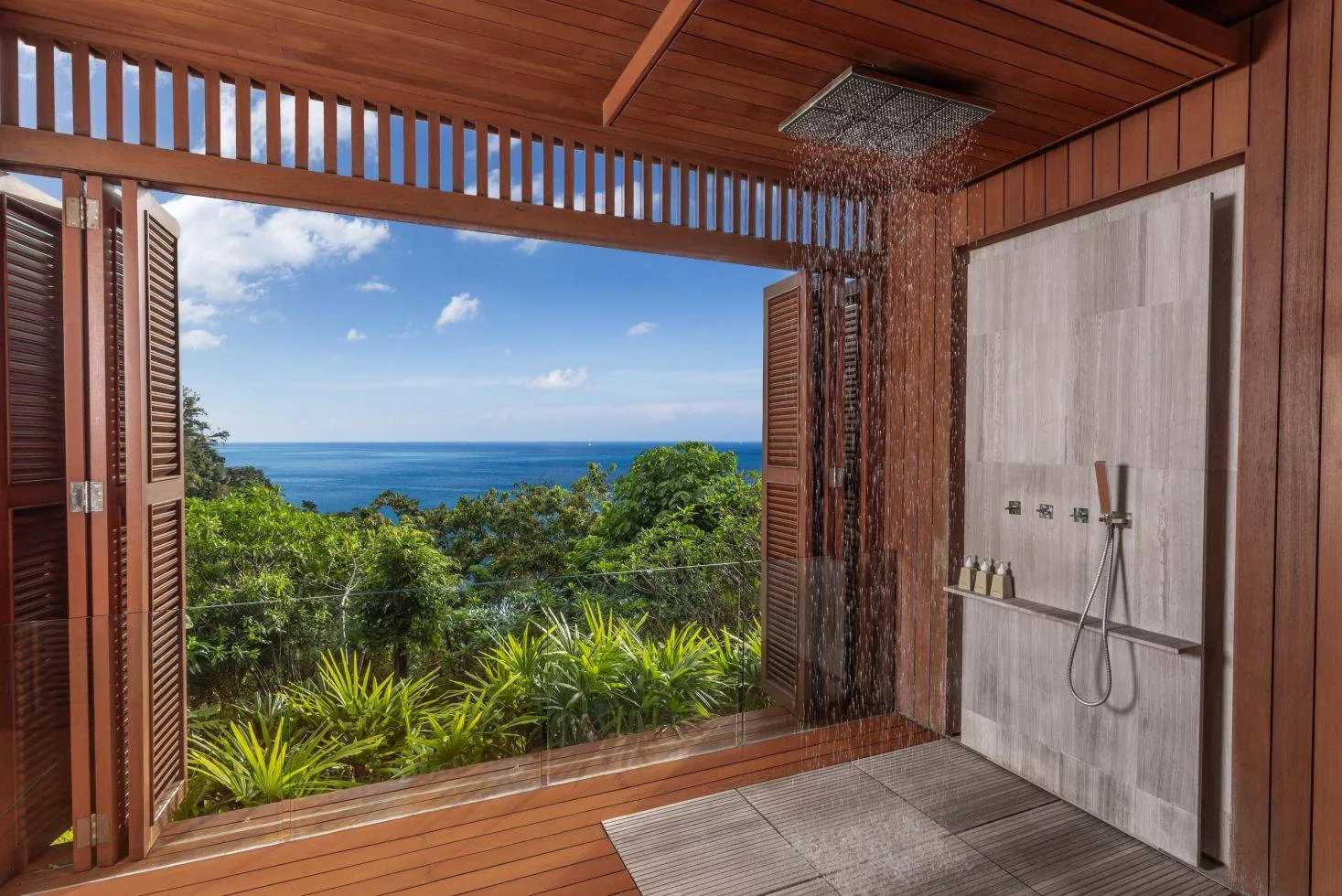 An outdoor shower area open to a sea view