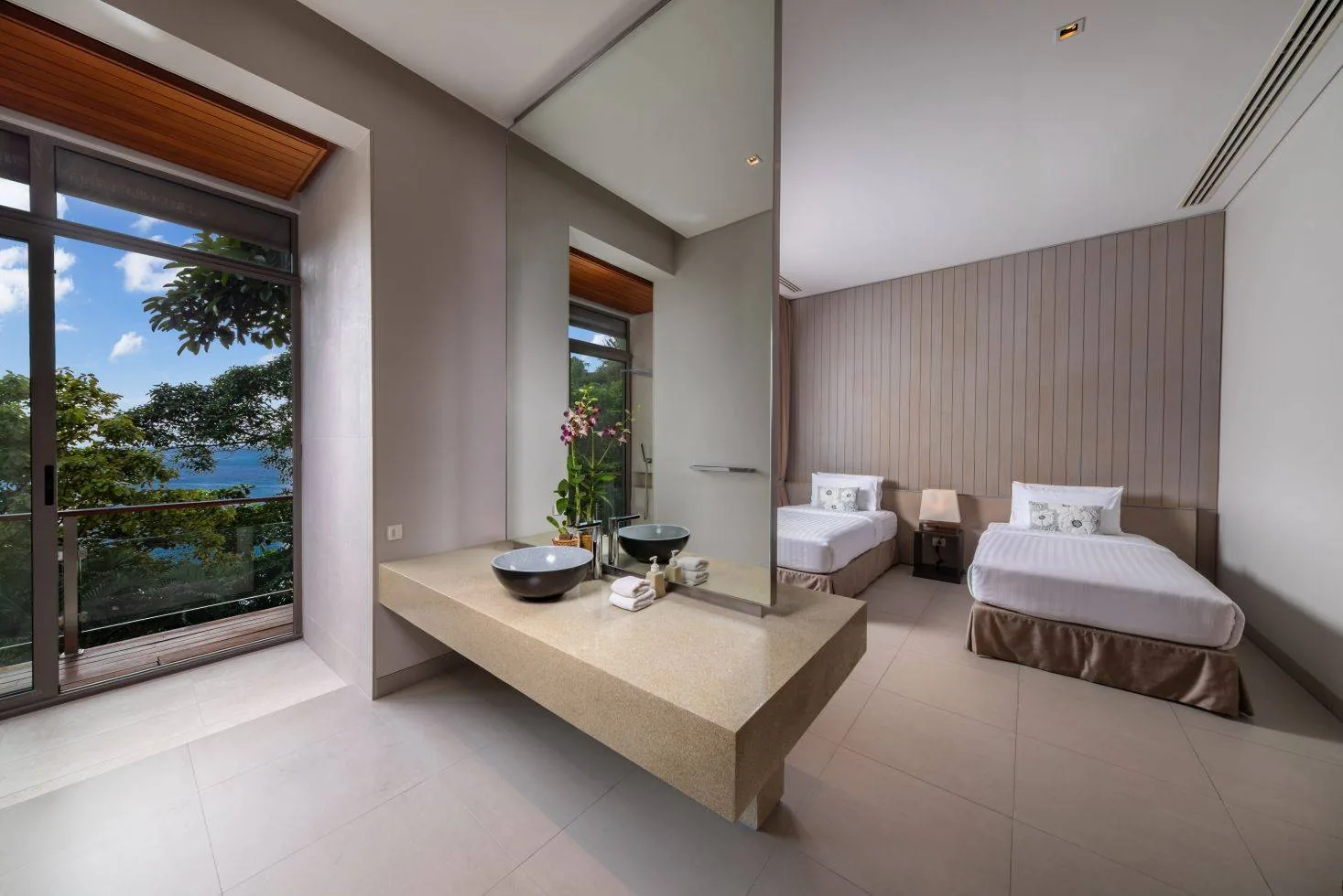 A twin bedroom with two single beds and a window with a view