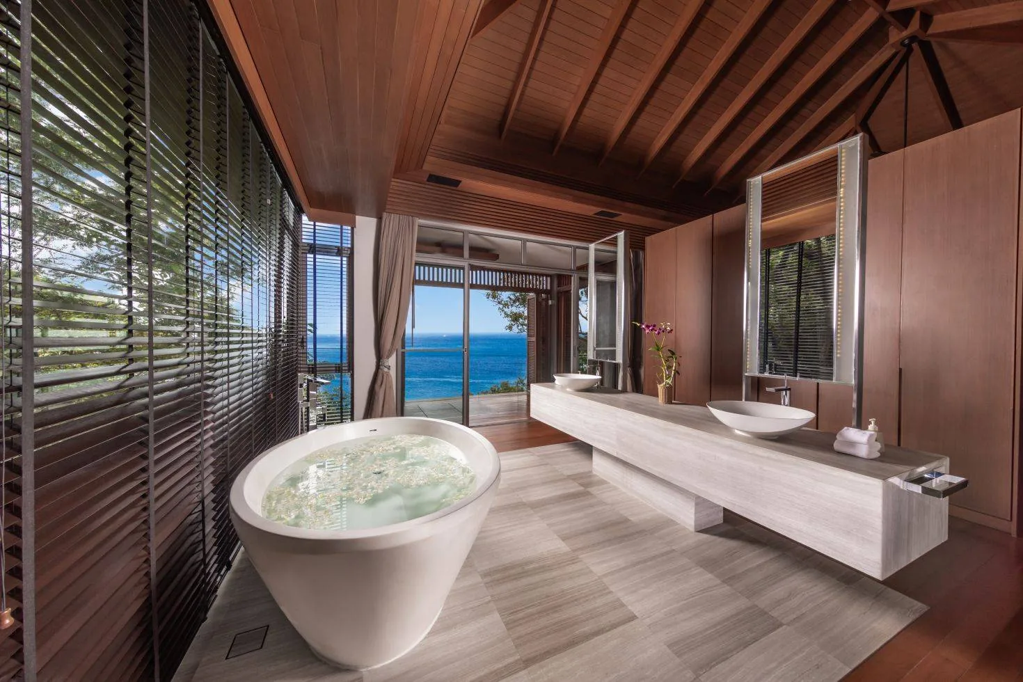 A bathroom with a round freestanding tub and a double vanity