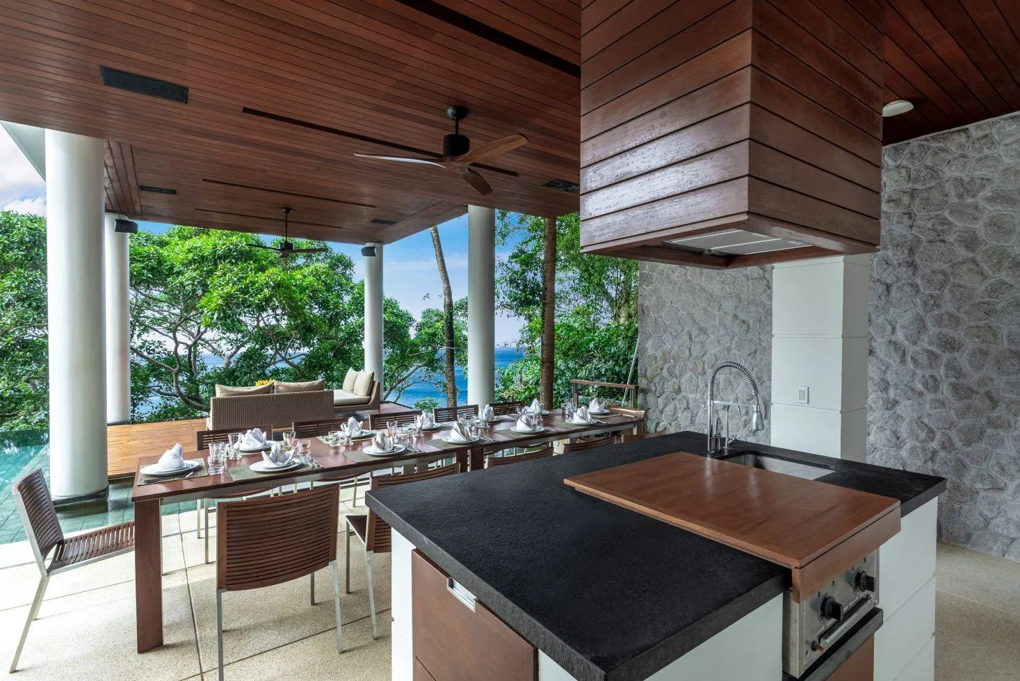 An open plan dining table and kitchen counter with a sea view beyond