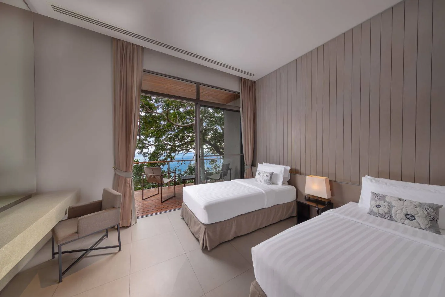 A twin bedroom with two single beds and a sea view