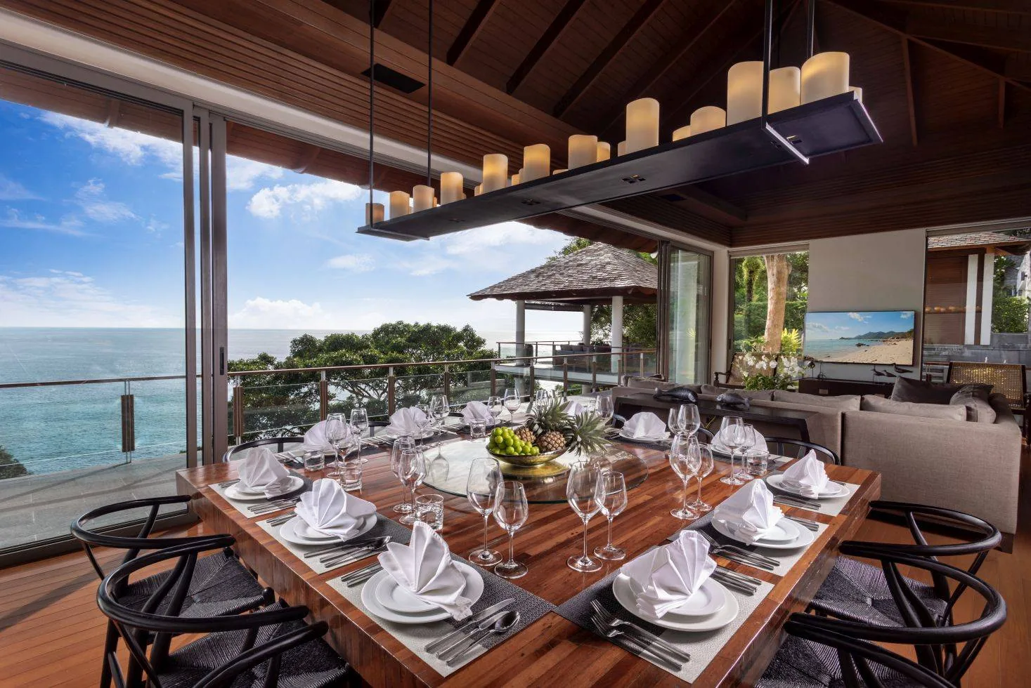 A dining table set for a meal, with an indoor living area behind